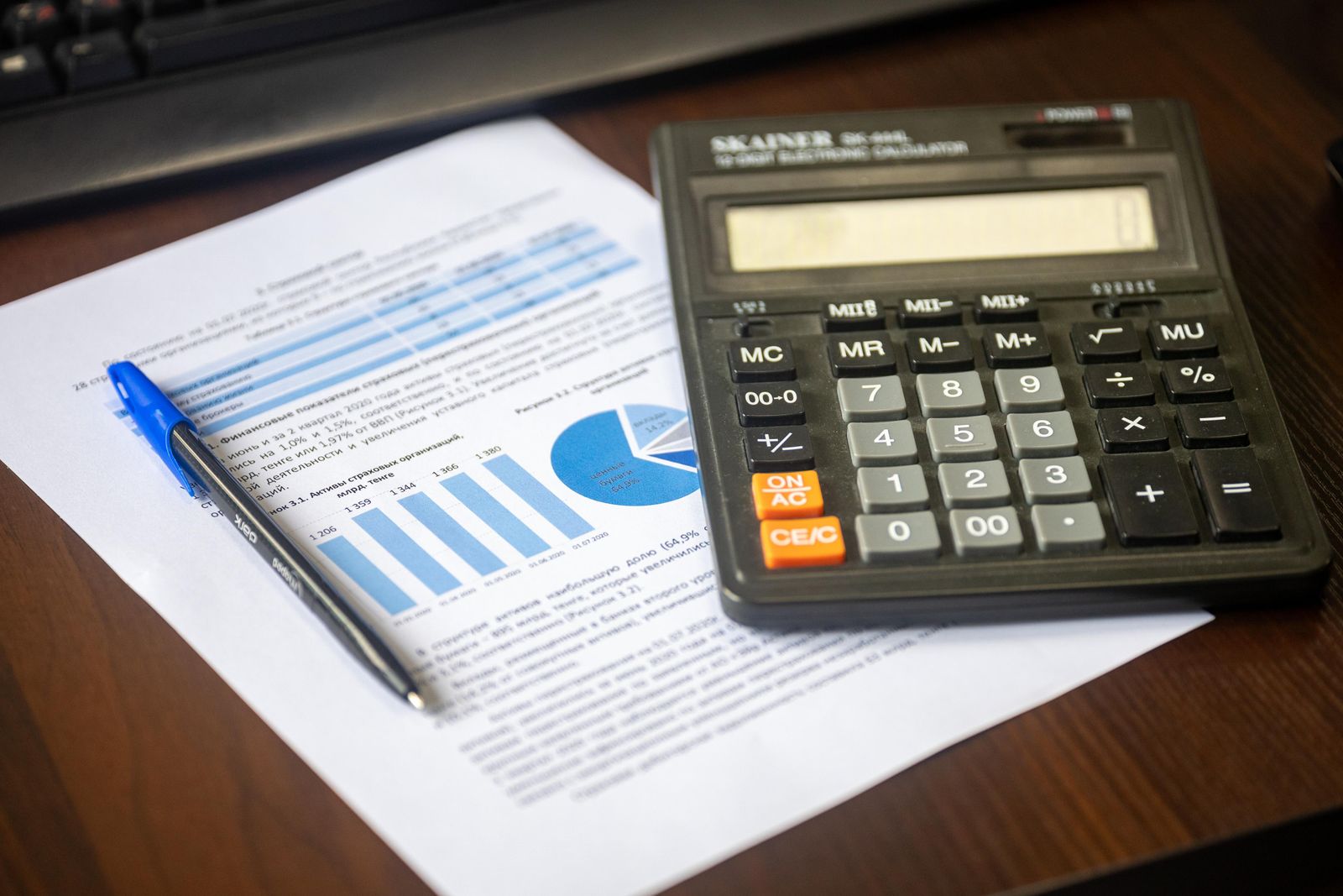 Stock photograph of a professional checking financial paperwork with a calculator